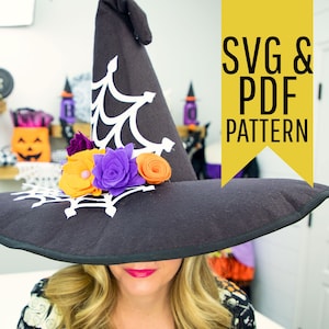 Op de afbeelding: Een zwarte vilten heksenhoed met een wit spinnenwebontwerp en een omhooggekrulde rand. De hoed is versierd met vilten bloemen in oranje, paars en geel. De tekst "SVG & PDF PATTERN" staat in een gele doos.