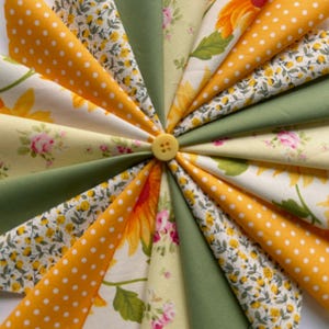 May include: A collection of fabric squares in shades of yellow, green, and white with floral and polka dot patterns. The fabric squares are arranged in a circular pattern with a button in the centre.