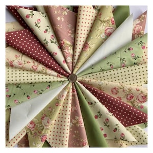 May include: A collection of 18 fabric squares in a variety of floral and polka dot patterns. The fabrics are in shades of green, pink, cream, and brown.