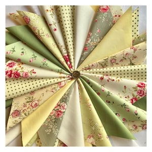 May include: A collection of 16 fabric squares in various shades of green, yellow, and white with floral and polka dot patterns.