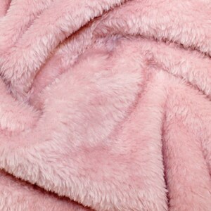 K&ouml;nnte beinhalten: Nahaufnahme eines weichen, rosa Kunstpelzes. Der Stoff hat eine flauschige Textur und einen dezenten Glanz.