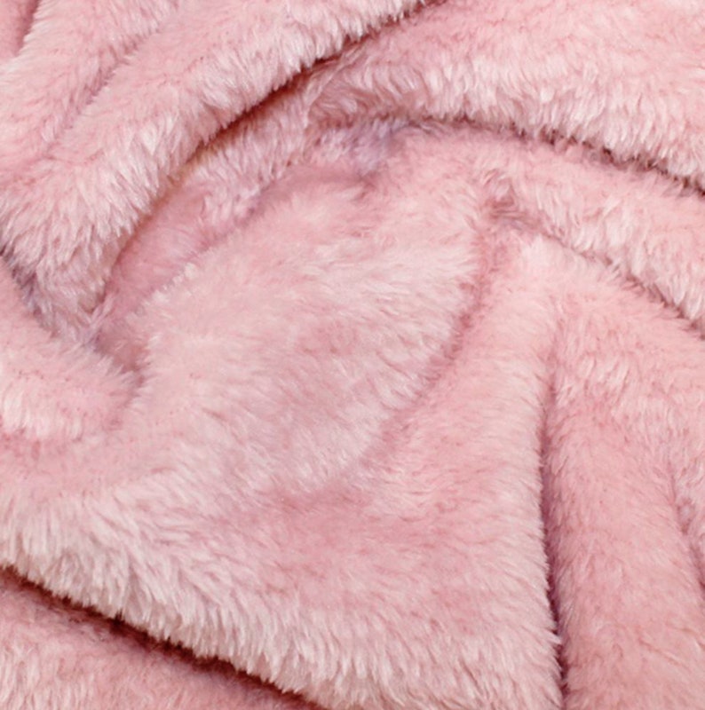 K&ouml;nnte beinhalten: Nahaufnahme eines weichen, rosa Kunstpelzes. Der Stoff hat eine flauschige Textur und einen dezenten Glanz.