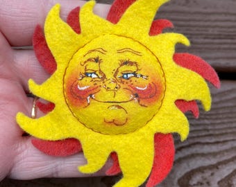 Broche vintage con un adorable sol sonriente firmado por Annalee