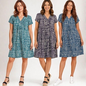 May include: Three women modelling short-sleeved dresses with a V-neck and a patterned design. The dresses are teal, purple, and blue. The woman on the left wears black sandals, the woman in the middle wears black sandals, and the woman on the right wears white trainers.