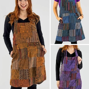 May include: Patchwork apron dresses in shades of orange, blue, and purple. Each dress features a bib top, large front pockets, and a knee-length skirt. The aprons have a variety of patterned fabric patches.