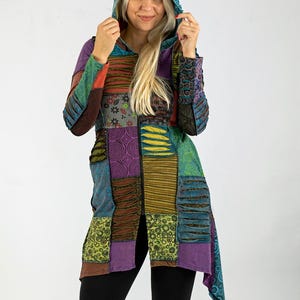May include: A patchwork hooded jacket in various colours, including purple, green, and blue. The jacket features a mix of patterned fabrics and a long, flowing design. The hood is a solid teal colour.