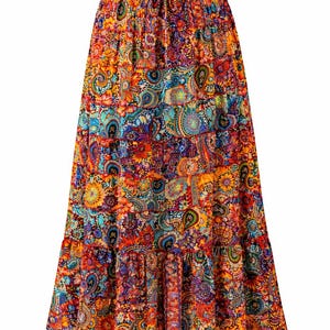 May include: A long, tiered skirt with a vibrant floral and paisley pattern. The skirt has a drawstring waist and a flowing shape. The dominant colours are orange, red, blue, and yellow, creating a bohemian style, with a length of approximately 90 cm.