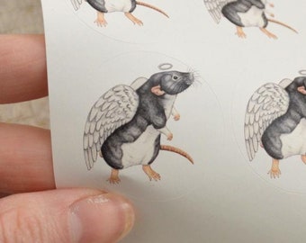 May include: Sheet of stickers featuring a black and white rat with angel wings and a halo. The rat is standing on all fours with its wings spread out. The stickers are on a white background.