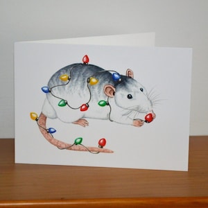 Carte de Noël de rat, rat rouan avec des lumières de Noël, carte de voeux de rats de Noël