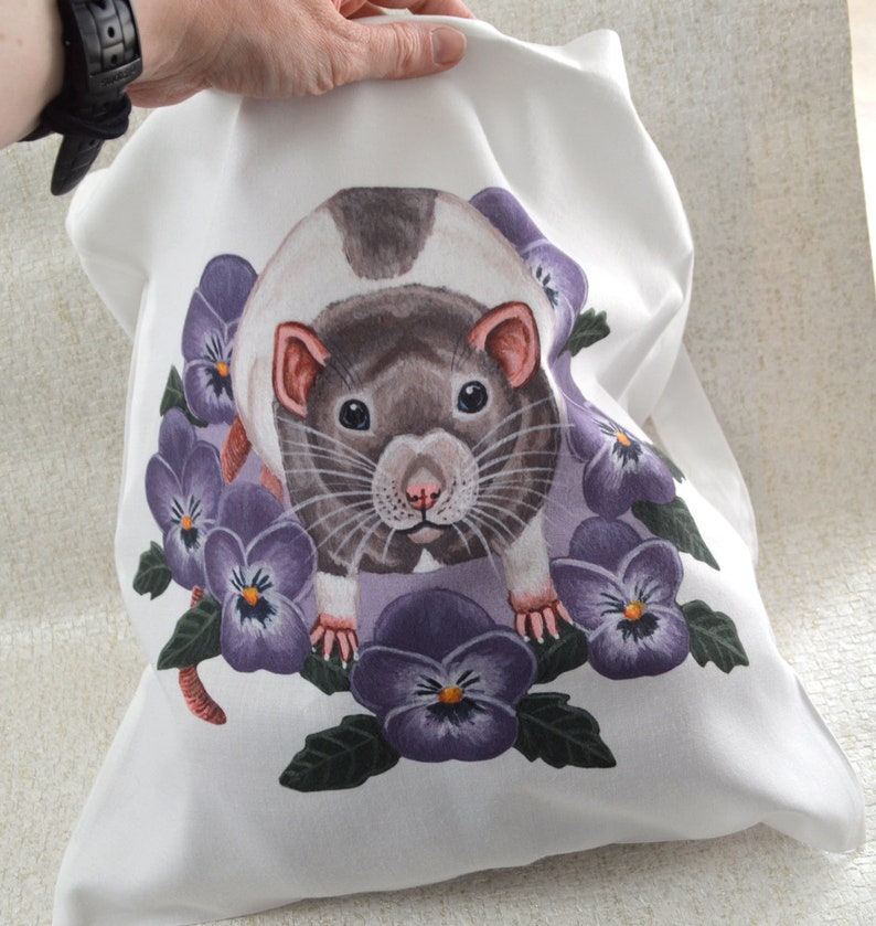 May include: White pillowcase with a watercolour illustration of a rat and purple pansies. The rat has grey and white fur, pink ears and nose. The pansies have dark purple petals and yellow centres.
