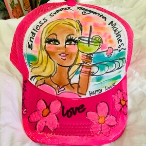 K&ouml;nnte beinhalten: Rosa-farbener Netz-Trucker-Hut mit handgemaltem Design einer Frau mit blonden Haaren, die ein Margarita-Glas h&auml;lt. Der Hut tr&auml;gt den Text "Endless Summer Margarita Madness!" und "Happy Hour". Auf dem Hut befinden sich rosa Blumen mit dem Wort "love" in Schwarz.