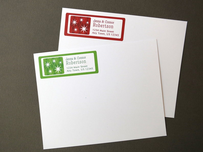 May include: Two red and green address labels with a starburst design. The labels read "Jenna & Connor Robertson 1234 Main Street Any Town, US 12345".