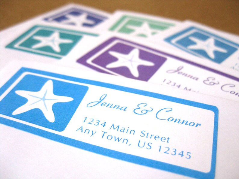 May include: A blue and white wedding invitation with a starfish design. The invitation reads "Jenna & Connor" and includes the address "1234 Main Street, Any Town, US 12345".