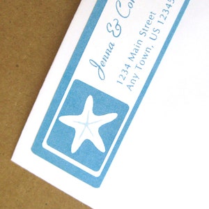 May include: A blue and white return address label with a starfish design. The label reads "Jenna & Connor, 1234 Main Street, Any Town, US 12345".