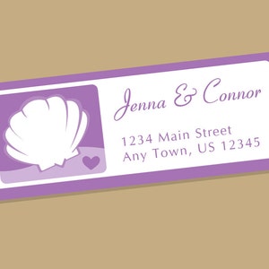 May include: Purple return address label with a white seashell and a small heart in the left corner. The text reads "Jenna & Connor" and "1234 Main Street Any Town, US 12345".