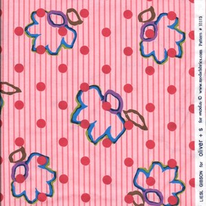 Peut inclure: Tissu rose avec un motif répété de pois rouges et de feuilles stylisées bleues, vertes et violettes. Le tissu a de fines rayures roses. Le texte "WORKSHOP by LIESL GIBSON for OLIVER + S for moda fabrics.com © moda Pattern # 11173" est imprimé sur le côté droit du tissu.