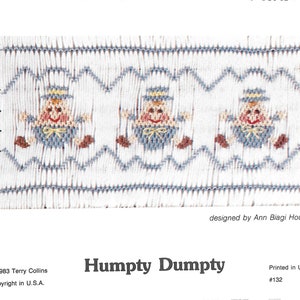May include: White fabric with a repeating pattern of Humpty Dumpty characters in blue, brown, and yellow. The design includes a zig-zag border in blue. The text "Humpty Dumpty" is below the design.