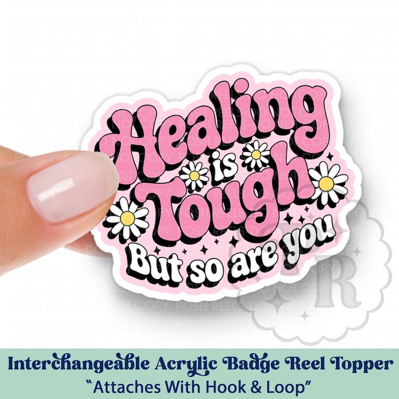 May include: Pink and white acrylic badge reel topper with the text "Healing is tough but so are you" in a retro font with daisy accents.