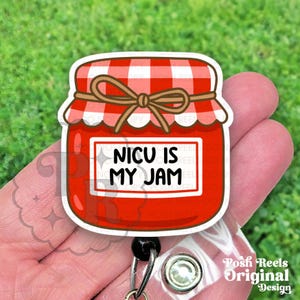 May include: A red and white gingham-topped badge reel featuring a cartoon jar of jam. The jar has a label that reads "NICU IS MY JAM". The badge reel is a Posh Reels Original Design.