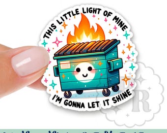 May include: A round sticker with a green and blue trash can with a smiling face and flames on top. The text "This little light of mine I'm gonna let it shine" is written around the trash can.