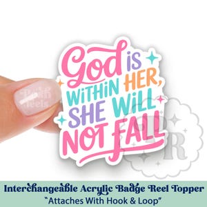 May include: An interchangeable acrylic badge reel topper with the text "God is WITHIN HER, SHE WILL NOT FALL" in pink, blue, purple, and orange. The topper is held by a hand and has the words "Interchangeable Acrylic Badge Reel Topper" at the bottom.