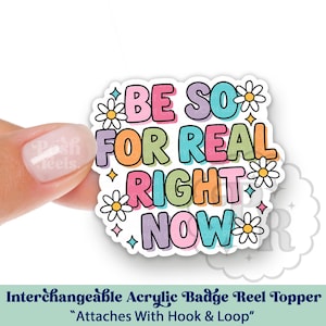 May include: A colorful acrylic badge reel topper with the phrase "BE SO FOR REAL RIGHT NOW" in bubble letters. The design includes daisies and stars. The topper attaches with hook and loop.