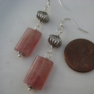 May include: A pair of dangle earrings with pink and clear quartz rectangular beads and silver tone metal accents.