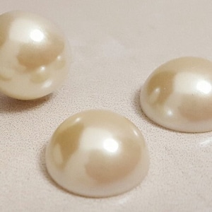 May include: Four white pearl buttons, two are round and two are flat.