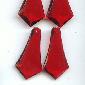May include: Four red crystal teardrop shaped pendants. The pendants are faceted and have a pointed tip. They are approximately 2 inches long.
