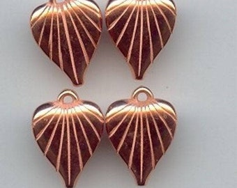 May include: Four copper-colored heart-shaped charms with a fan-shaped design. Each charm has a small loop at the top for attaching to jewelry or other crafts.