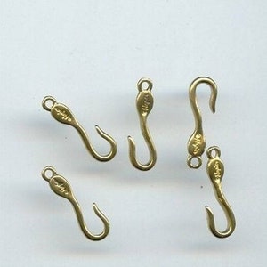 May include: Five gold-toned metal hooks with a small loop at the top and a hook at the bottom. The hooks are all the same size and shape.