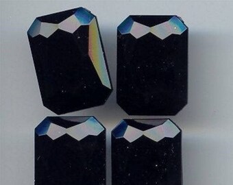 May include: Four black iridescent rectangular glass gems with a faceted design.