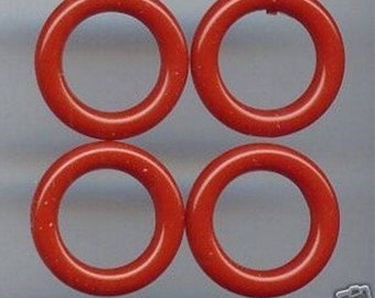May include: Four red rubber rings, each with a circular hole in the centre. The rings are arranged in a square pattern.