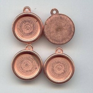 May include: Four copper-colored metal pendant trays with a circular shape and a raised edge. Two of the trays have a concentric circle design, while the other two are smooth.