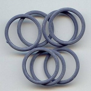 May include: A set of six gray rubber O-rings. The rings are stacked on top of each other.