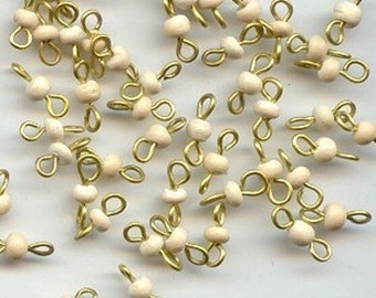 May include: A group of gold-toned metal bead caps with white beads. The bead caps have two loops on each side.