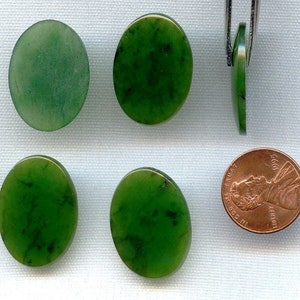 May include: Four oval-shaped green jade cabochons, each approximately the size of a UK penny. The cabochons are smooth and polished, with a slight variation in colour and pattern.