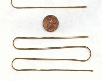 May include: Four gold chains laid out in a row on a white surface. A penny is placed in the middle of the chains for size comparison.