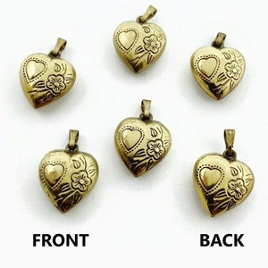 May include: Six gold-tone heart-shaped pendants with floral designs. The pendants are shown from both the front and back.  The pendants have a loop at the top for attaching to a chain.