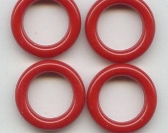 May include: Four red plastic rings, each with a smooth, circular shape and a hole in the centre.