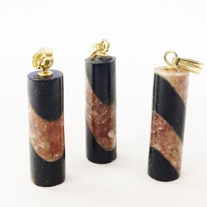 May include: Three black and brown marble pendant charms with gold-tone jump rings. The marble is swirled in a diagonal pattern.