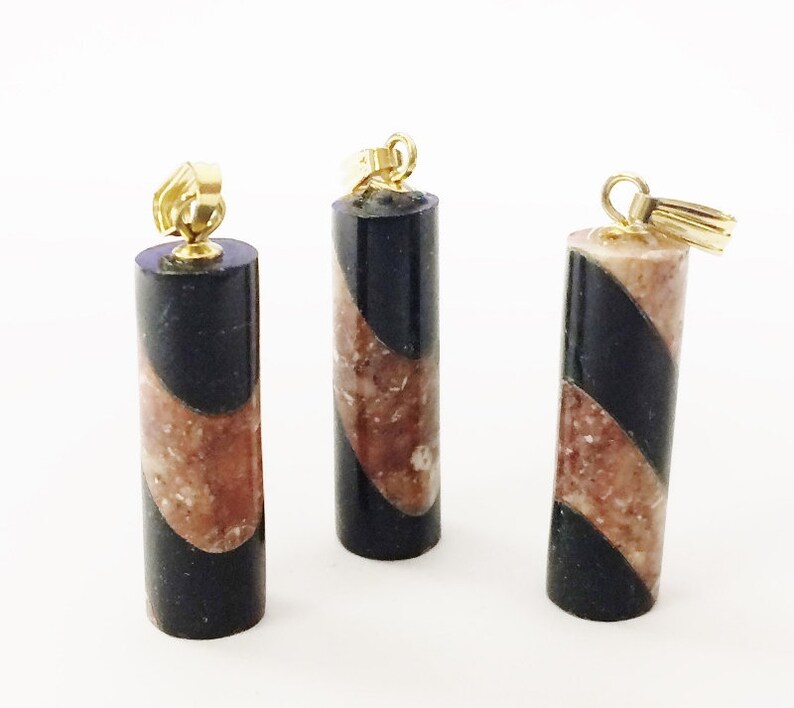 May include: Three black and brown marble pendant charms with gold-tone jump rings. The marble is swirled in a diagonal pattern.