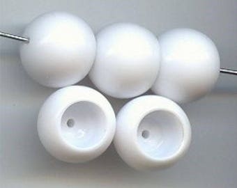 May include: Six white plastic beads with a hole in the center of each bead. The beads are round and smooth.