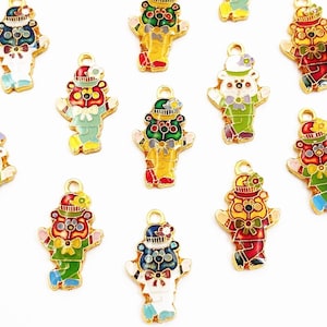 Peut inclure: Charmants breloques ours en émail coloré avec des détails en métal doré. Chaque breloque représente un ours portant un chapeau et un nœud papillon, dans diverses combinaisons de couleurs, rouge, vert, bleu et jaune. Idéal pour la création de bijoux.