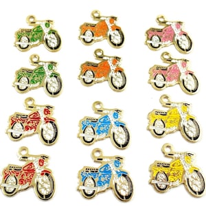 Könnte beinhalten: Zwölf goldfarbene Metall-Anhänger in Form von Motorrädern. Jeder Anhänger hat eine andere Farbe: Rot, Orange, Gelb, Grün, Blau, Rosa und Weiß. Die Anhänger sind mit schwarzen Umrissen und weißen Akzenten verziert.