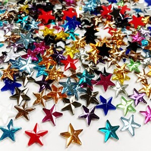 May include: Assortment of colorful star-shaped rhinestones in various sizes and colors, including red, blue, green, gold, and silver.