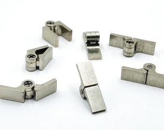 May include: A collection of small, silver-colored metal hinges. Each hinge has a rectangular base and a cylindrical pivot point, secured with a small screw. The hinges are designed for various applications.