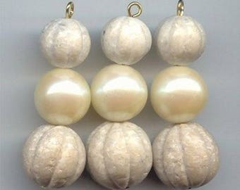May include: Three strands of white pearl and textured white beads with gold accents. Each strand has a pearl in the middle and two textured beads on either side.