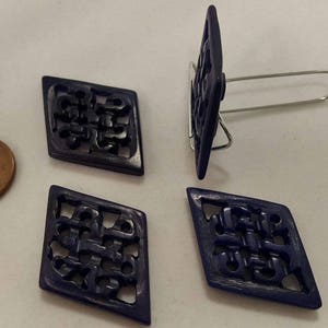 May include: Four dark blue diamond-shaped buttons with intricate carved designs. The buttons have a glossy finish and are perfect for adding a touch of elegance to any project.