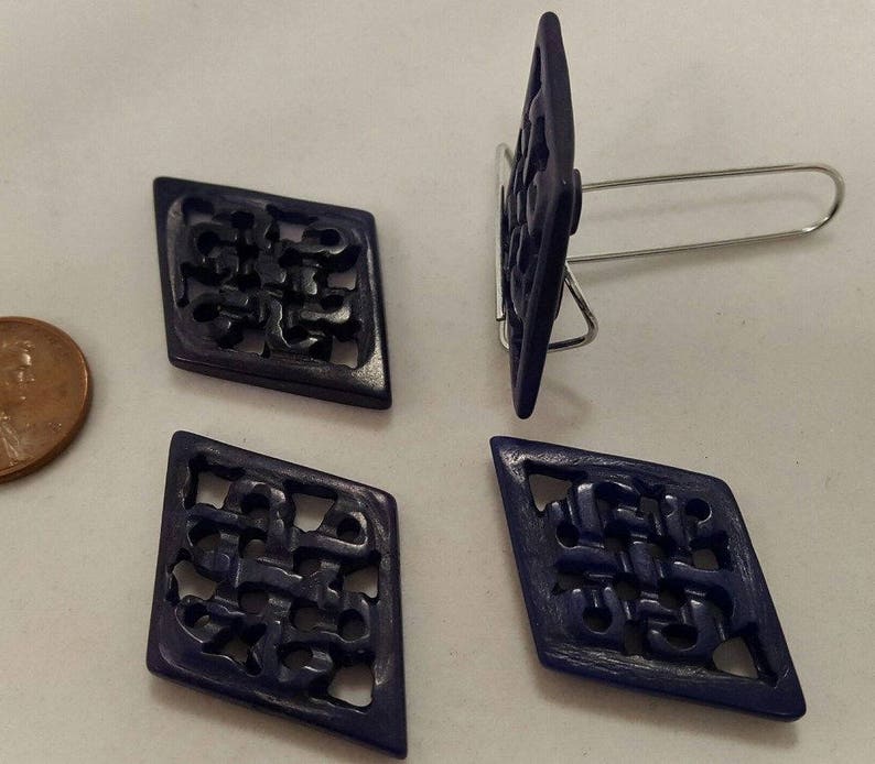 May include: Four dark blue diamond-shaped buttons with intricate carved designs. The buttons have a glossy finish and are perfect for adding a touch of elegance to any project.